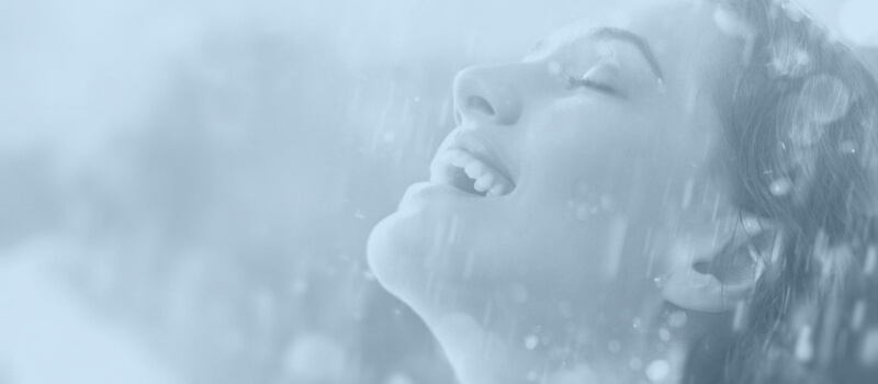 woman smiling while rain is falling on her face